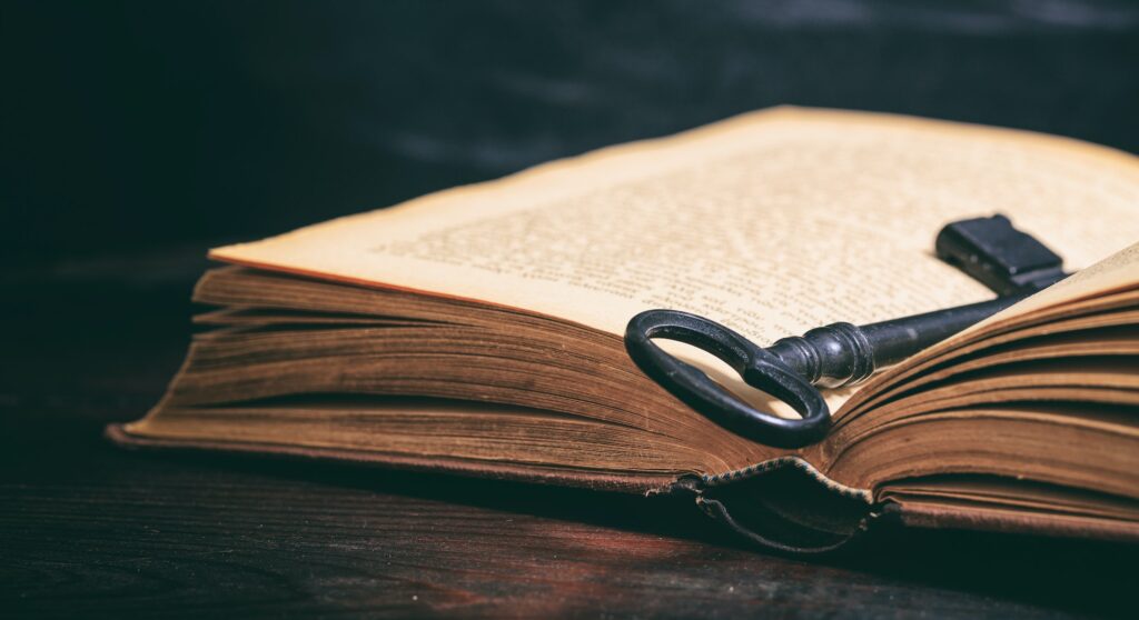 Key on a vintage book on wooden background